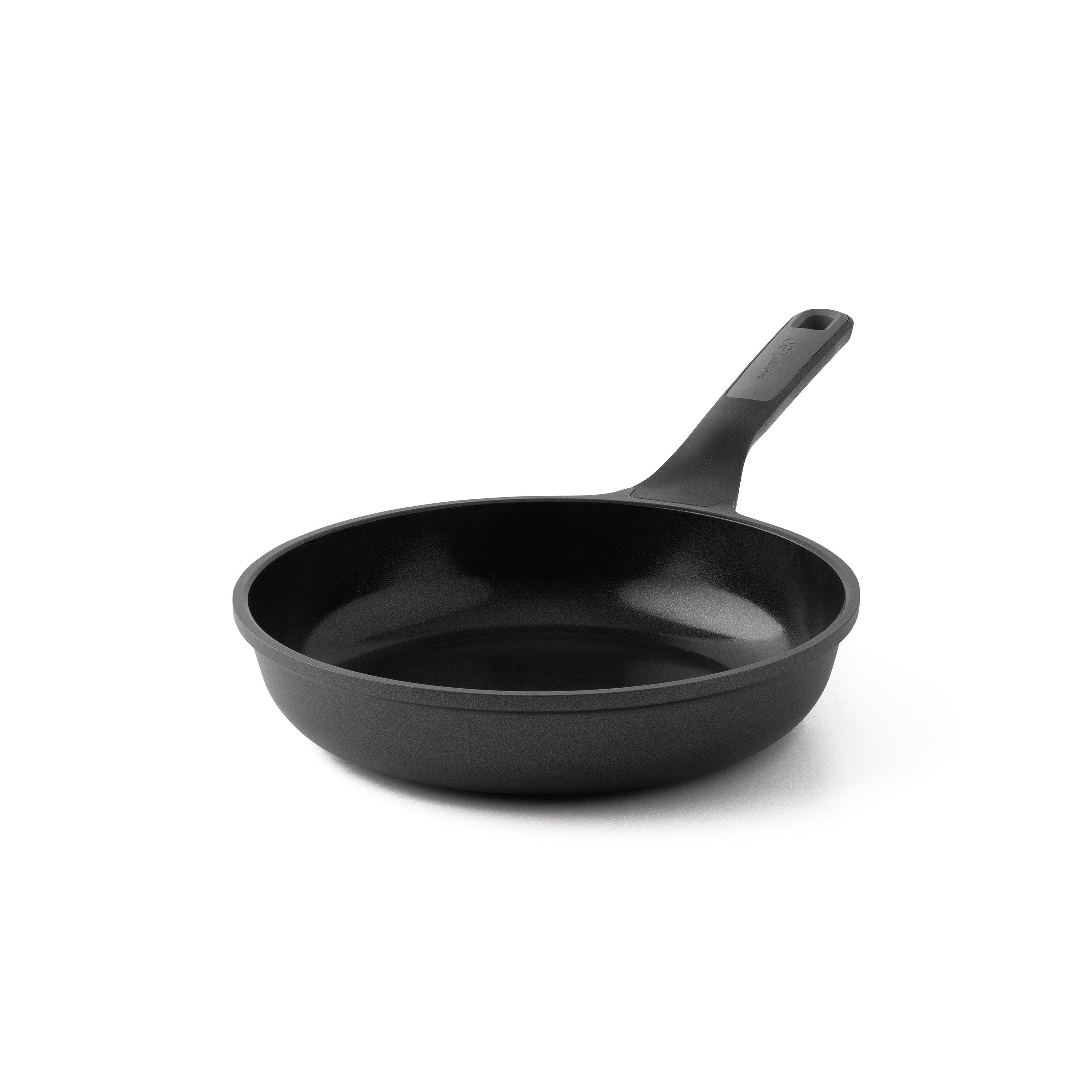 Een zwarte koekenpan met handvat staat op een witte achtergrond. De pan is leeg en klaar om te koken.