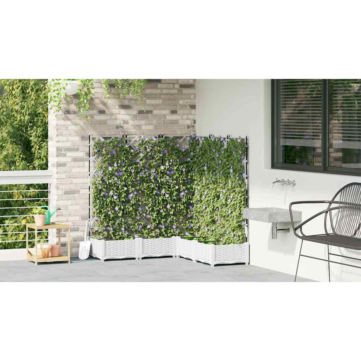 Un patio con un muro verde, fioriere bianche e una sedia nera. A sinistra una piccola mensola con vasi. Una finestra a destra.