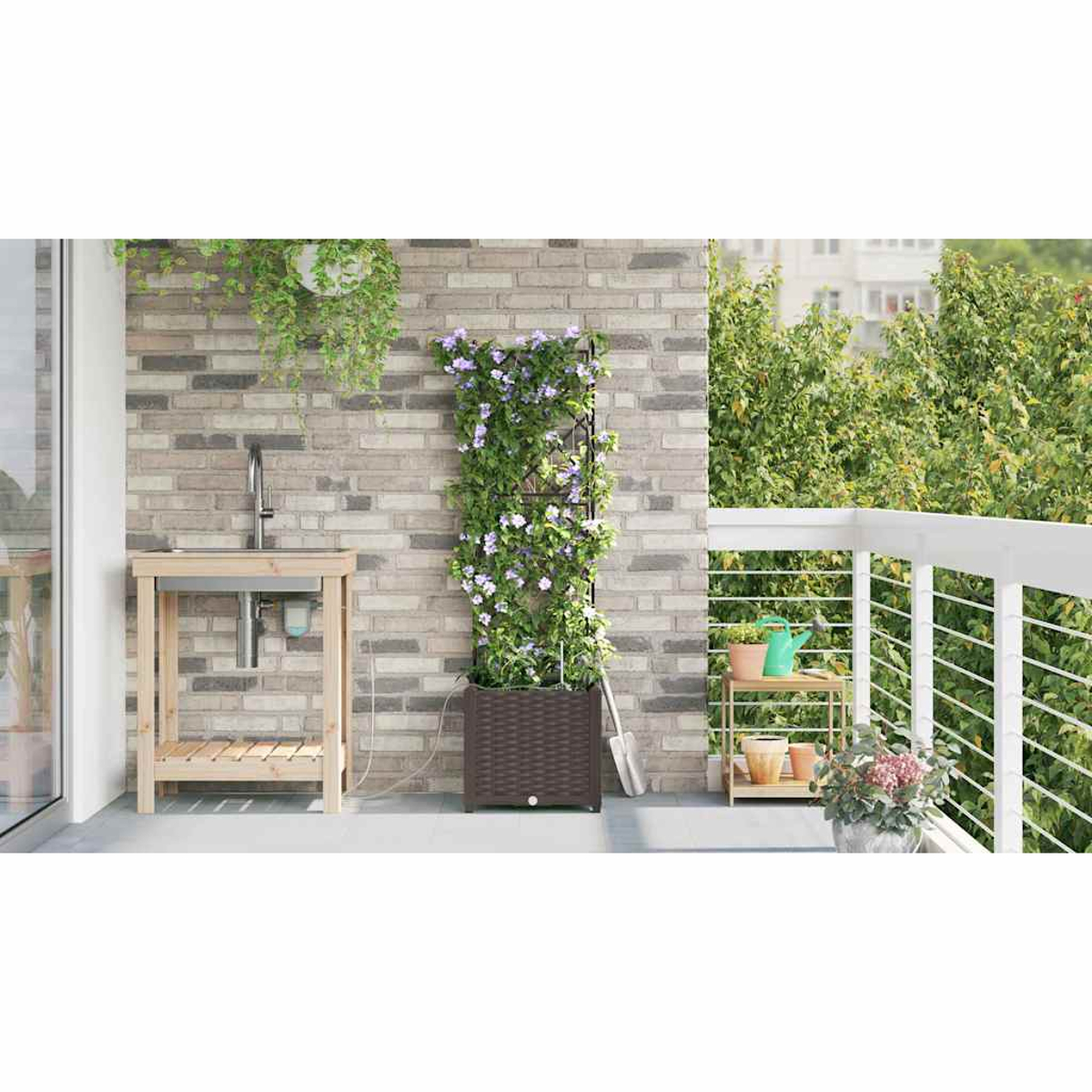 Giardino sul balcone con lavandino, muro di mattoni, pianta fiorita e piante in vaso. Fogliame verde sullo sfondo, ringhiera bianca e una pala.