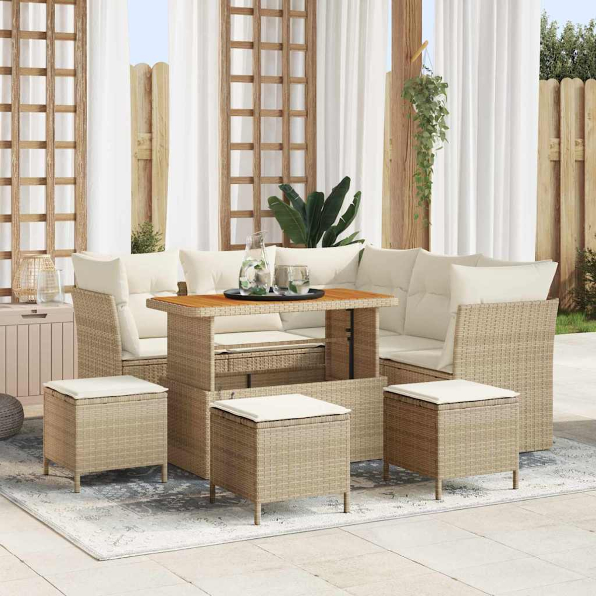 Garten-Set mit hellbraunen Korbmöbeln, weißen Kissen, einem Holztisch und passenden Hockern, vor dem Hintergrund von Vorhängen.