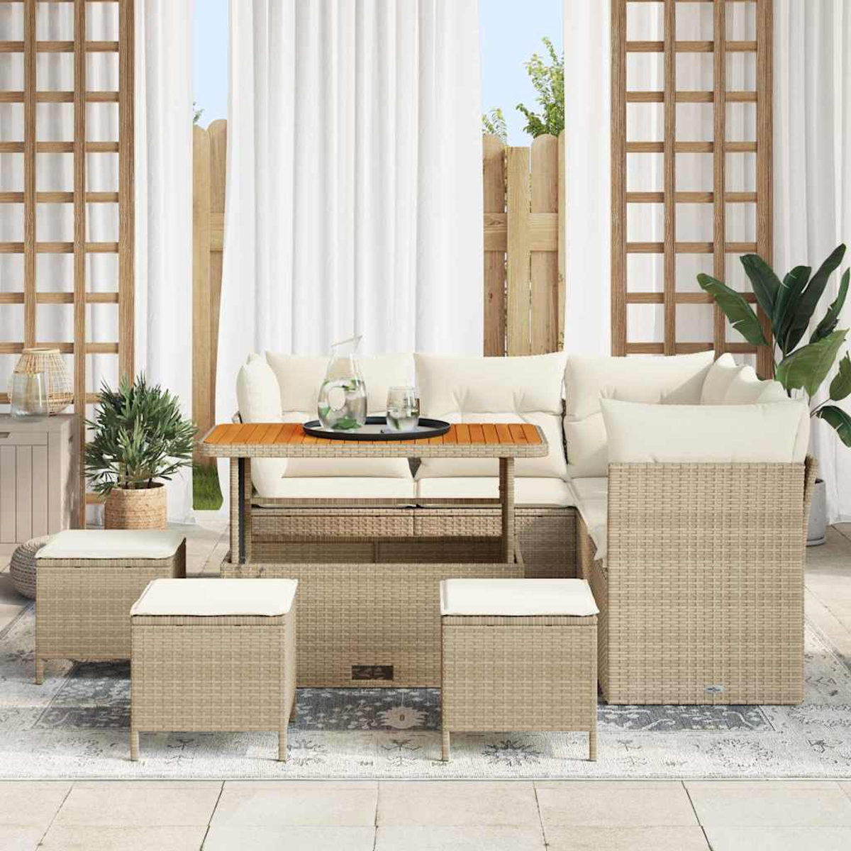 Terrassengarnitur mit beigen Korbmöbeln, weißen Kissen und einem Holztisch. Beinhaltet Sofa, Hocker und Vorhänge.