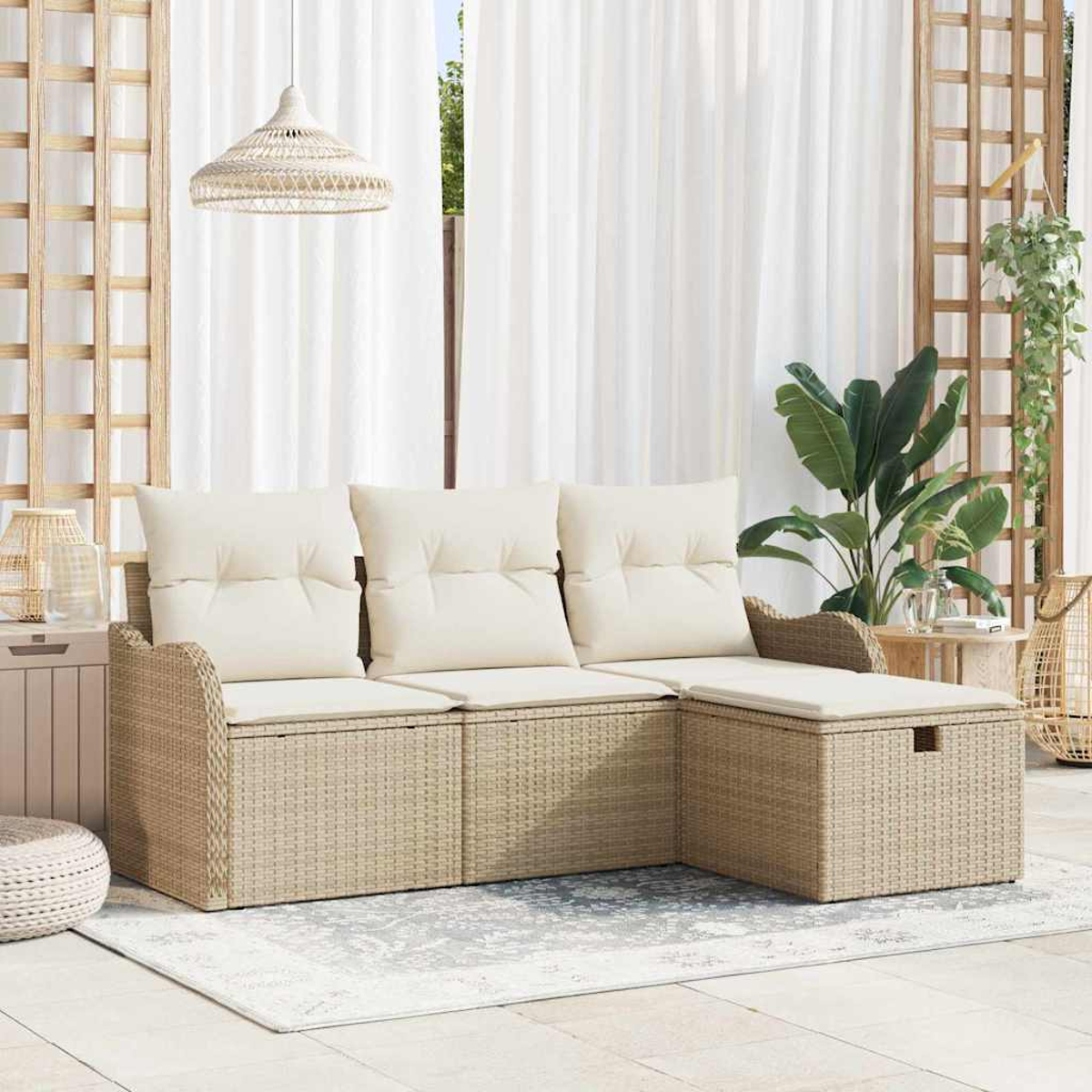 Wicker-Sofa mit cremefarbenen Kissen, auf einem gemusterten Teppich. Weiße Vorhänge, Pflanzen und eine Pendelleuchte sind im Hintergrund.
