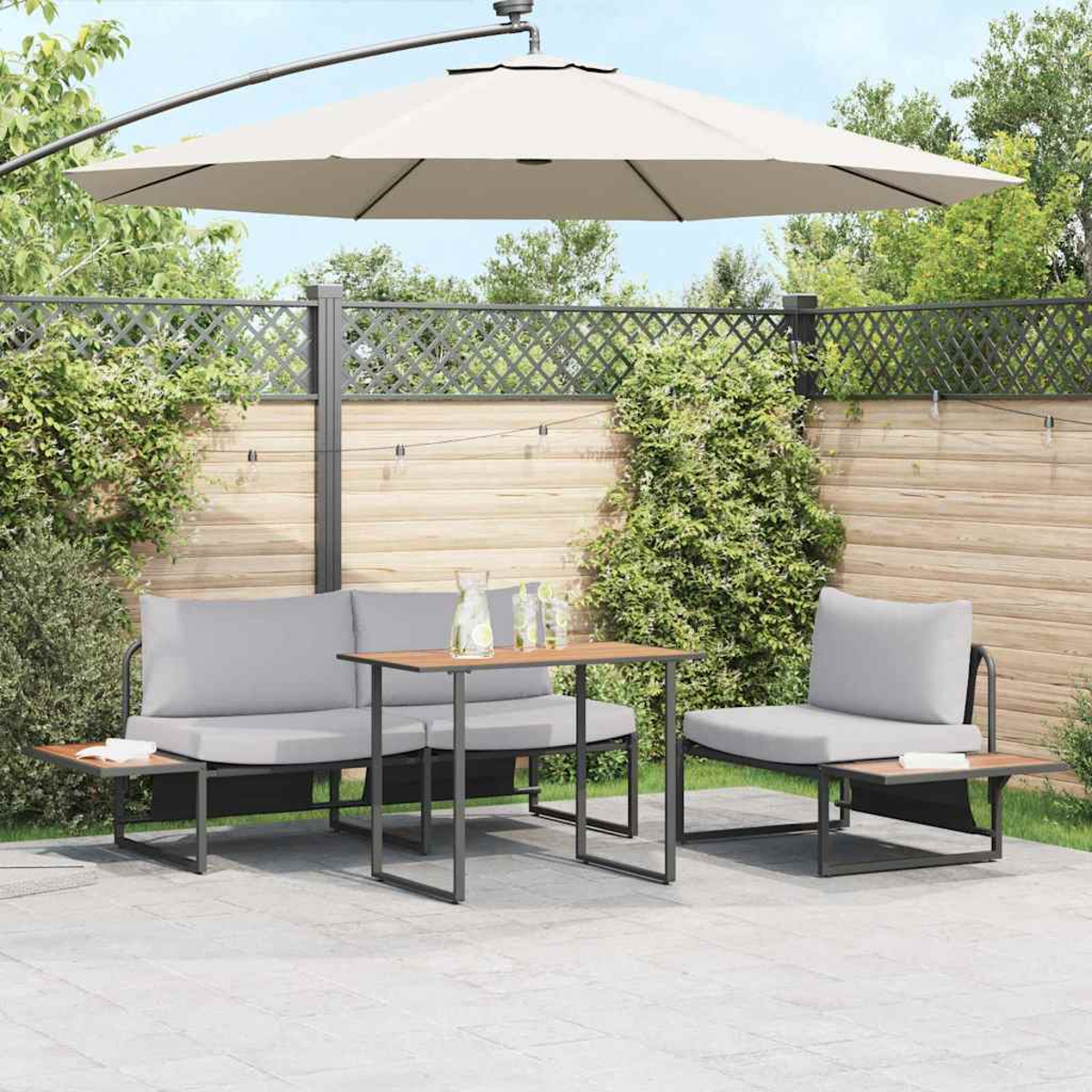 Terrassenset mit grauen Kissen, einem Holztisch und einem großen Sonnenschirm. Der Hintergrund umfasst einen Holzzaun und Grün.