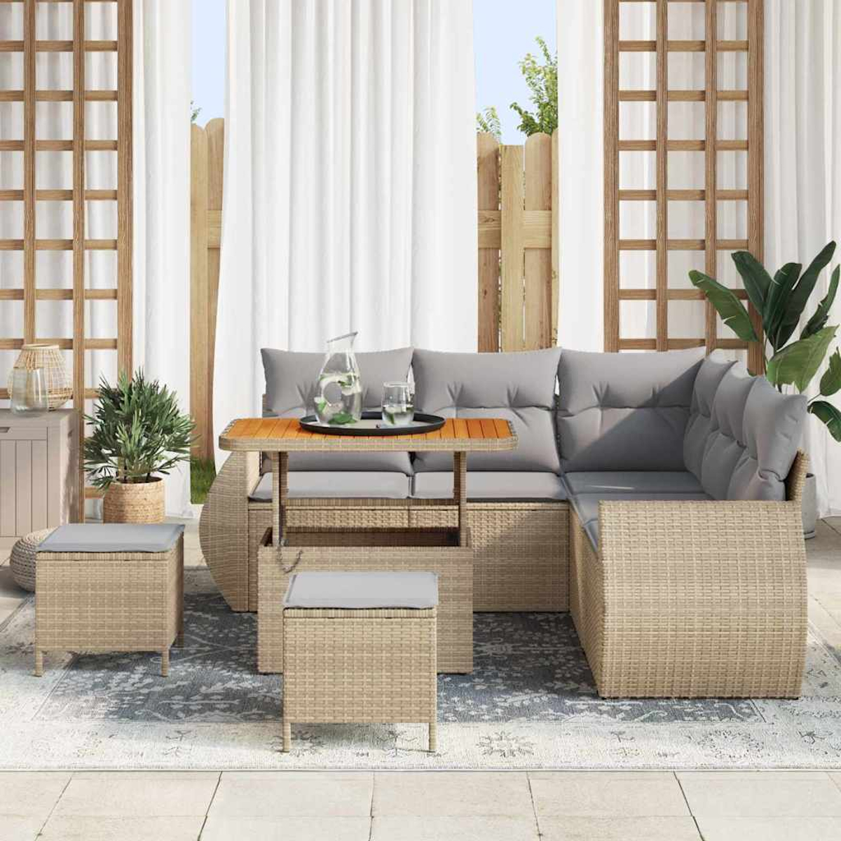 Outdoor-Wicker-Sofa mit grauen Kissen und einem Holztisch. Zwei Korbstühle und eine Topfpflanze sind ebenfalls zu sehen.