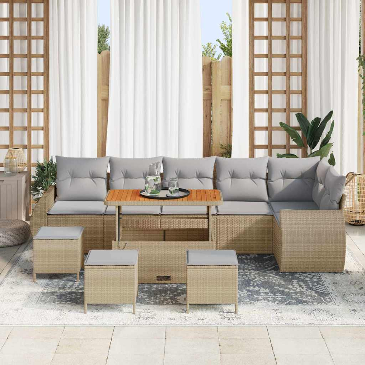 Outdoor-Ecksofa mit grauen Kissen, Holztisch und Hockern auf einem Teppich. Weiße Vorhänge und Holzgitter im Hintergrund.