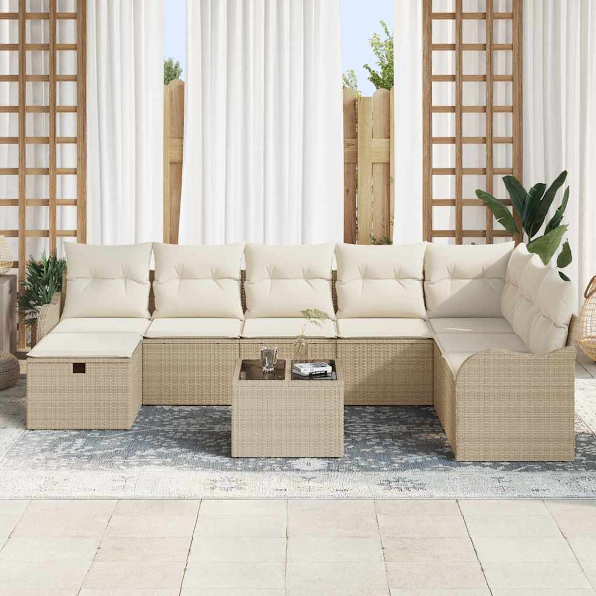 Ein Ecksofa im Freien mit cremefarbenen Kissen. Ein kleiner Tisch mit Glas und Büchern steht auf einem blau gemusterten Teppich.