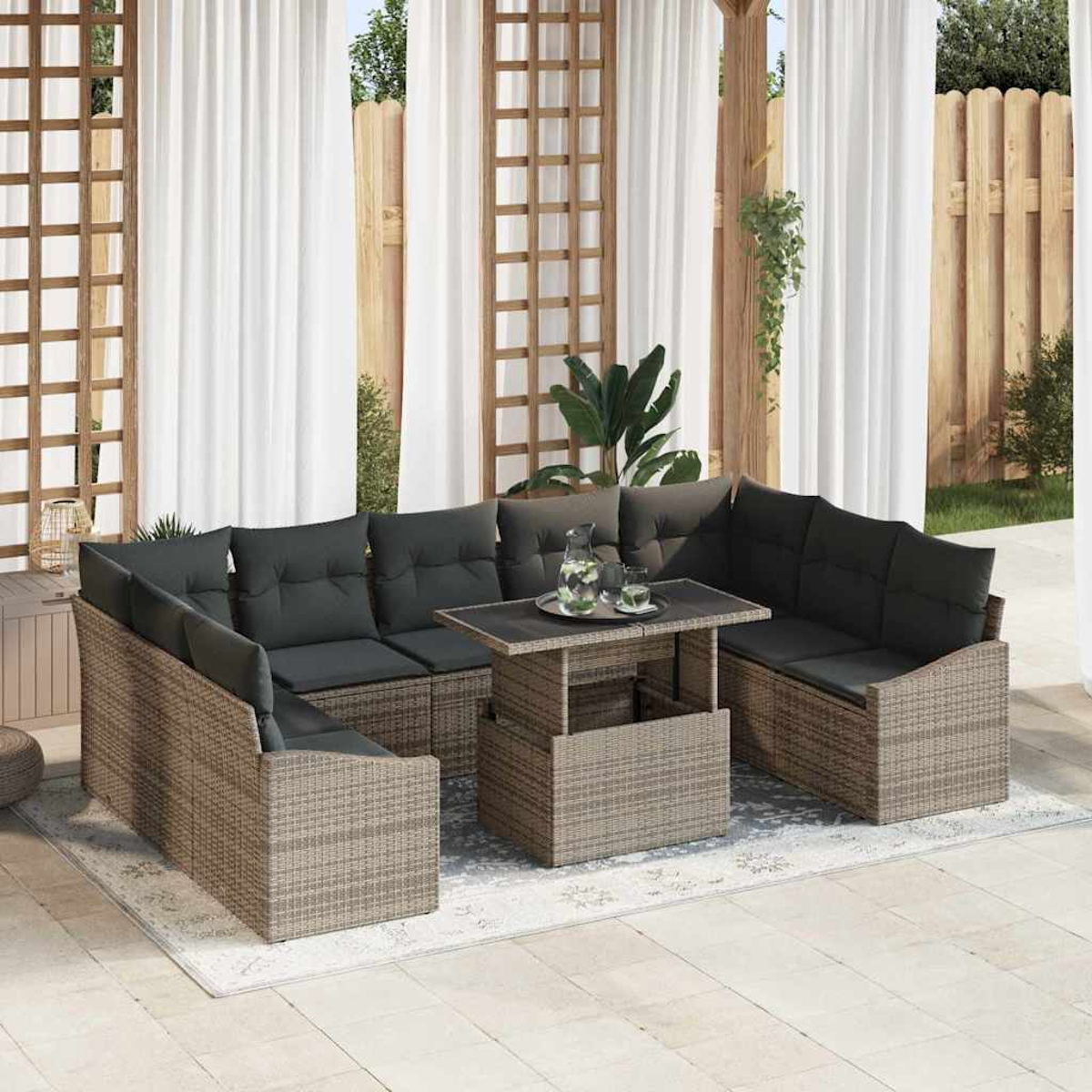 Ein Ecksofa im Freien mit grauen Kissen umgibt einen Tisch mit Hubfunktion. Weiße Vorhänge und ein Holzzaun sind im Hintergrund.