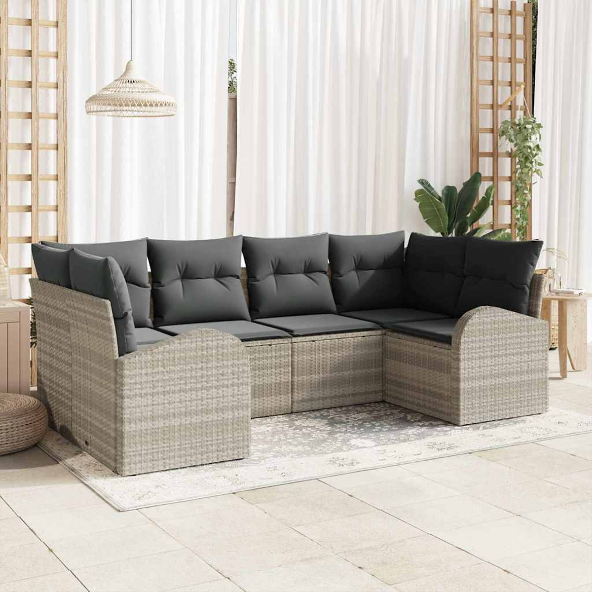 Outdoor-Ecksofa mit grauen Kissen auf einer Terrasse. Weiße Vorhänge und eine Hängeleuchte im Hintergrund.