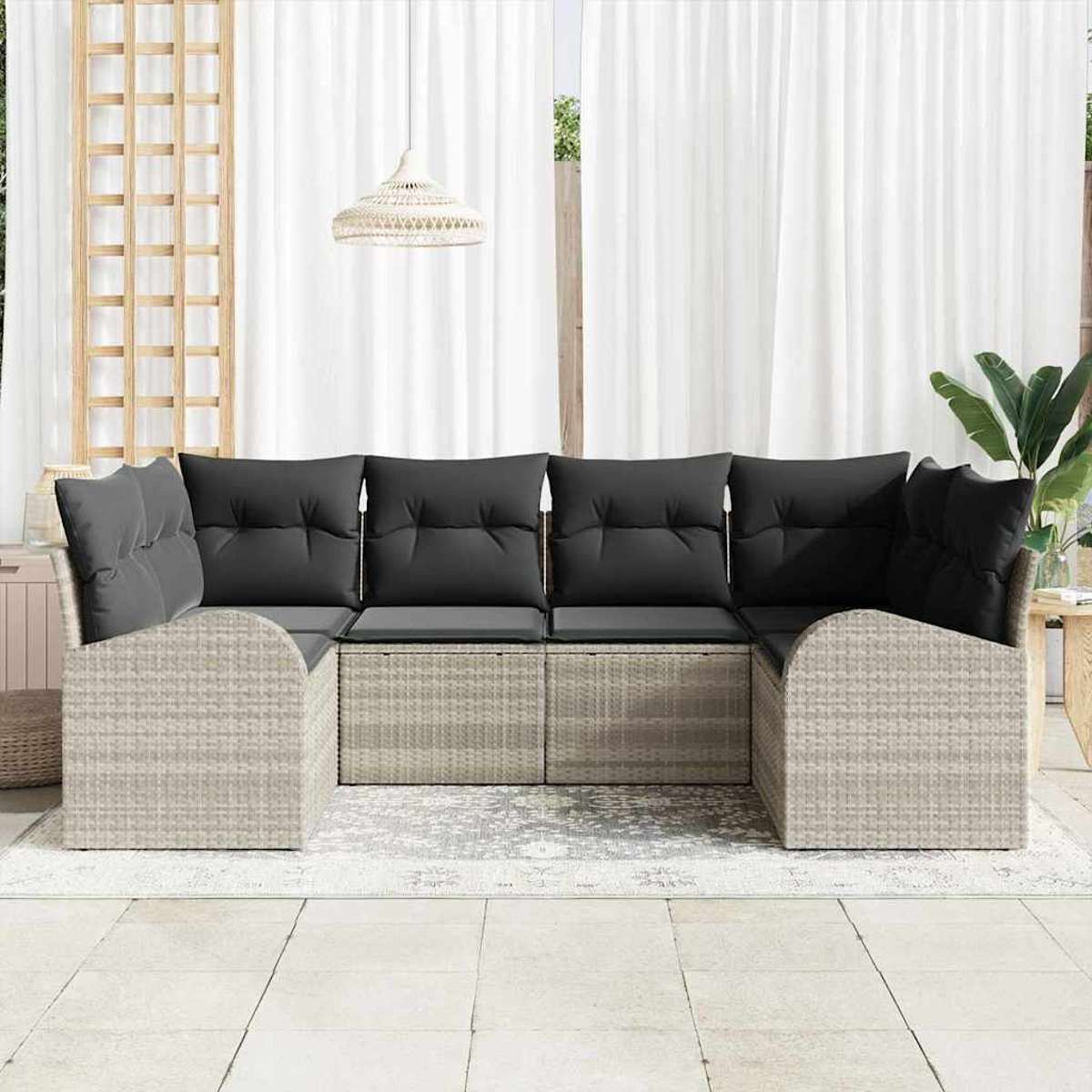 Outdoor-Ecksofa mit grauen Kissen. Weiße Vorhänge und eine gewebte Lampe hängen im Hintergrund. Unter dem Sofa liegt ein Teppich.