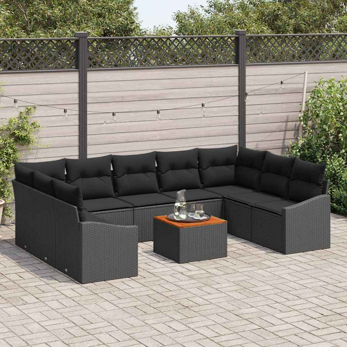 Outdoor-Ecksofa mit schwarzen Kissen und einem kleinen Tisch mit Getränken. Die Szene spielt in einem Hinterhof mit Zaun.