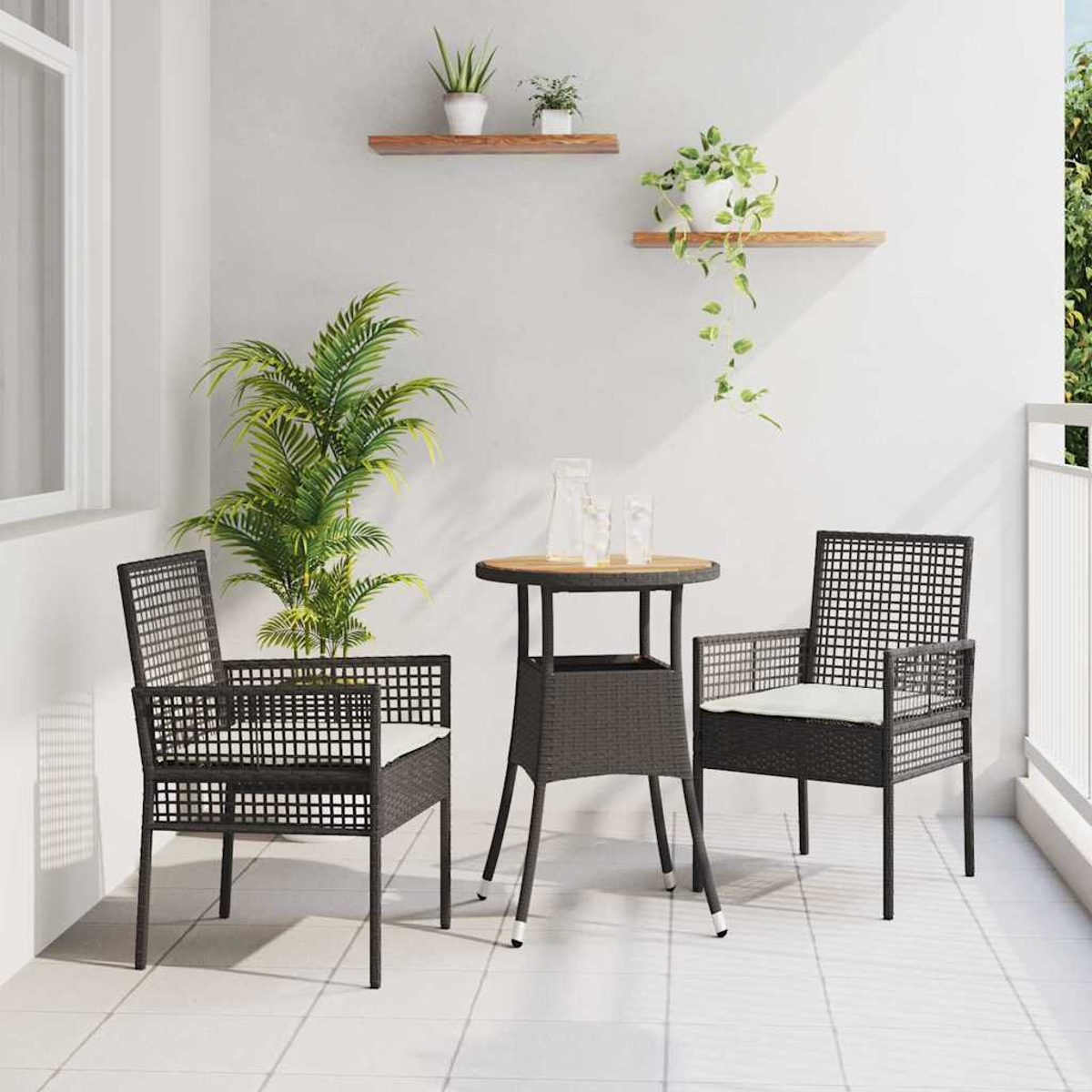 Escena de balcón con dos sillas negras, una mesa y plantas. Paredes blancas y suelo de baldosas. Se ven plantas verdes y macetas blancas.