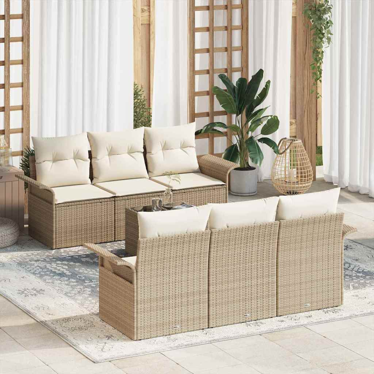 Szene im Freien mit zwei Rattansofas mit weißen Kissen. Im Hintergrund stehen eine große Topfpflanze und eine dekorative Laterne.