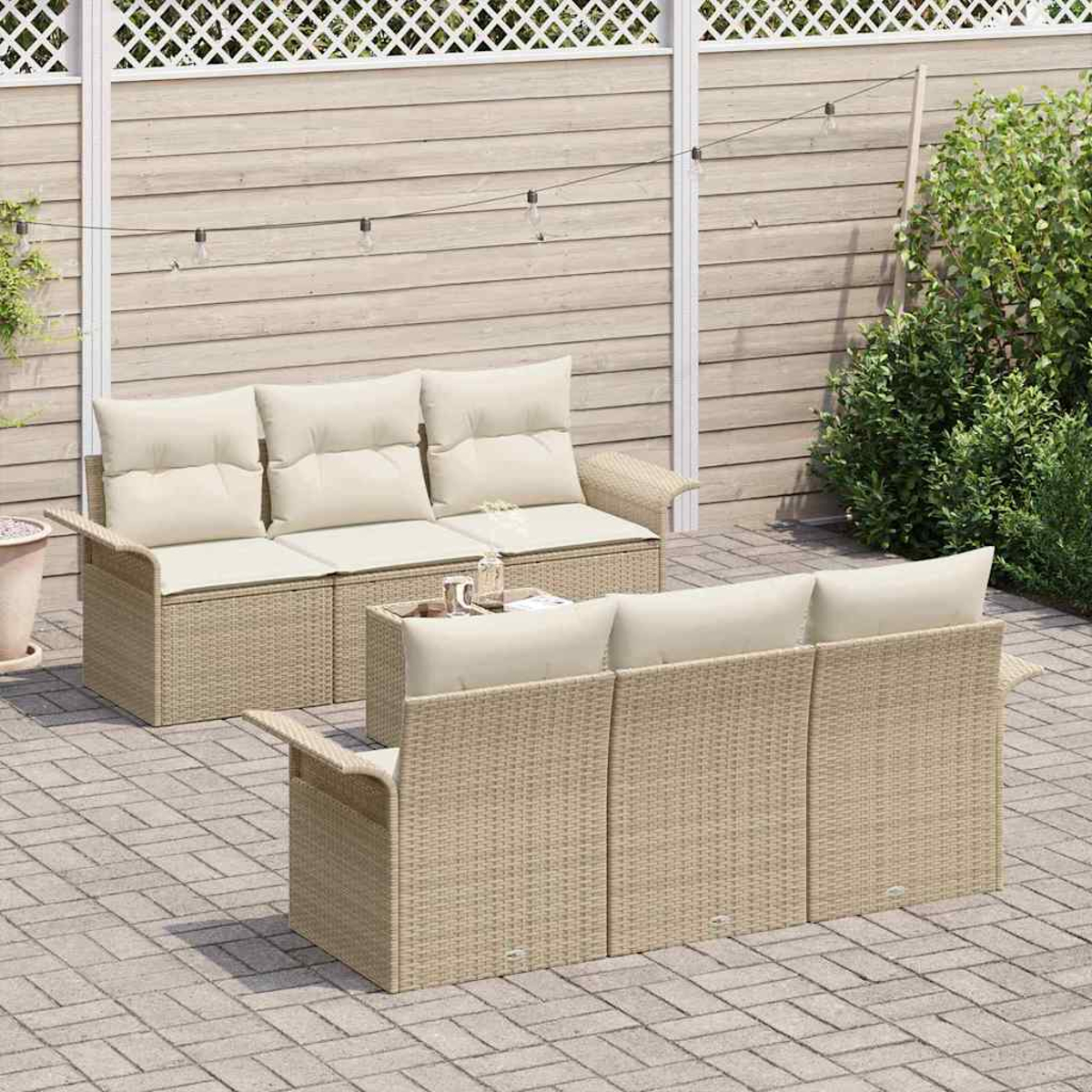 Zwei beigefarbene Korbs Sofas mit cremefarbenen Kissen auf einer Backstein-Terrasse. Ein kleiner Tisch mit Getränken steht dazwischen. Im Hintergrund ein Holzzaun.
