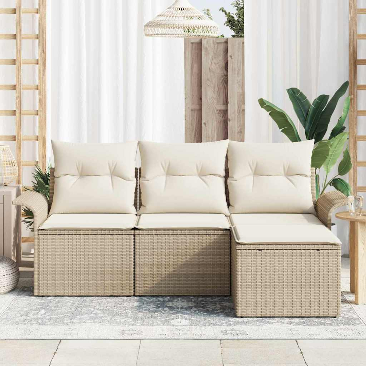 Beiges Korbschnittsofa mit cremefarbenen Kissen auf einem gemusterten Teppich mit Pflanzen und einem weißen Vorhang im Hintergrund.