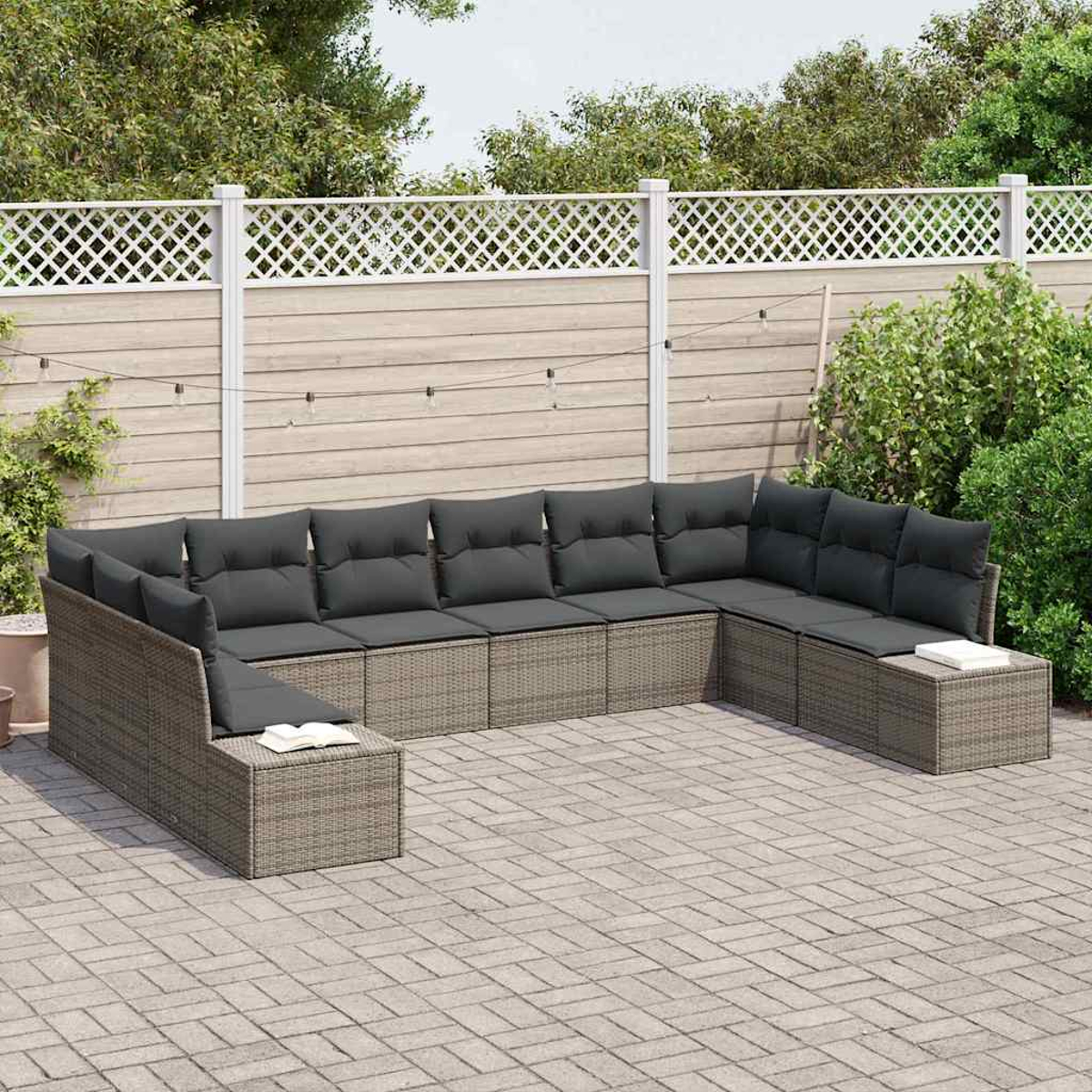Ein Ecksofa mit grauen Kissen steht auf einer Ziegelterrasse. Ein weißer Zaun und üppiges Grün bilden den Hintergrund.