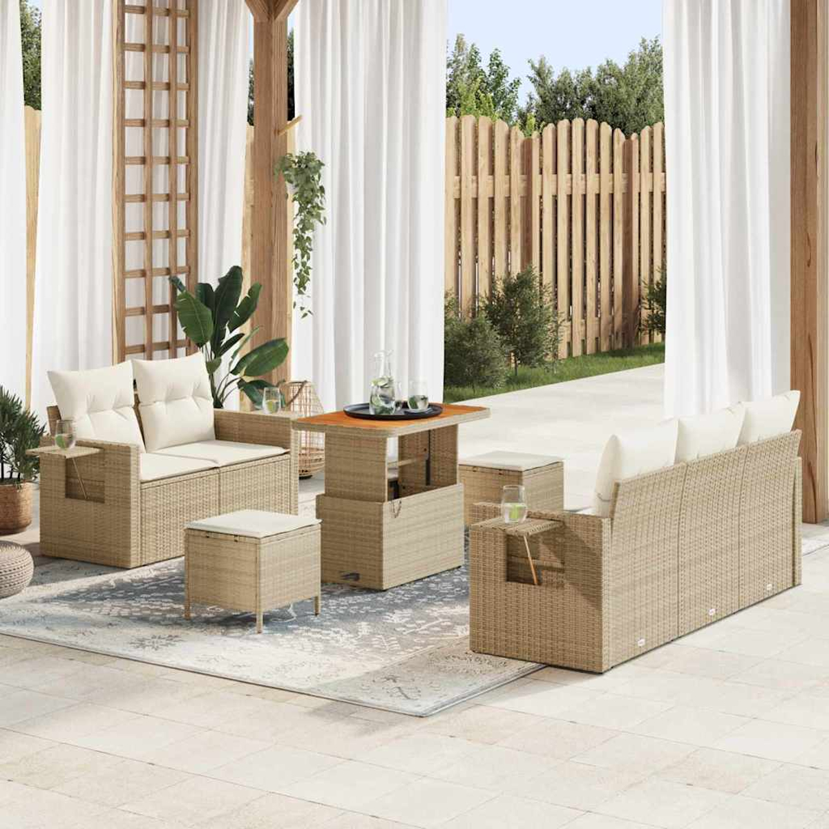 Außenbereich mit Rattansitzmöbeln, weißen Kissen und einem Holztisch. Weiße Vorhänge und ein Holzzaun sind im Hintergrund.