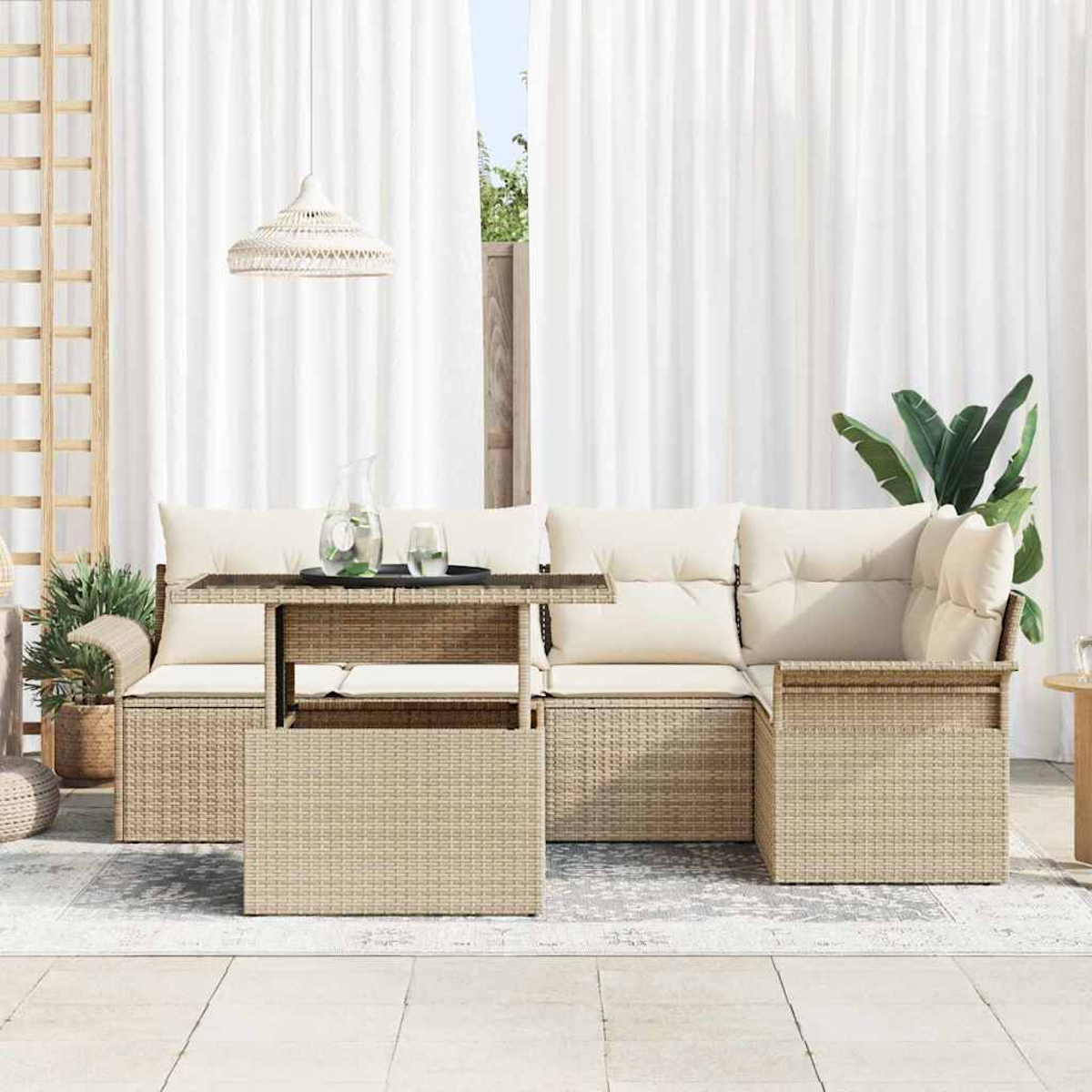 Escena al aire libre con muebles de mimbre, una mesa con bebidas, cortinas blancas y plantas en macetas. Una lámpara colgante cuelga sobre la mesa.