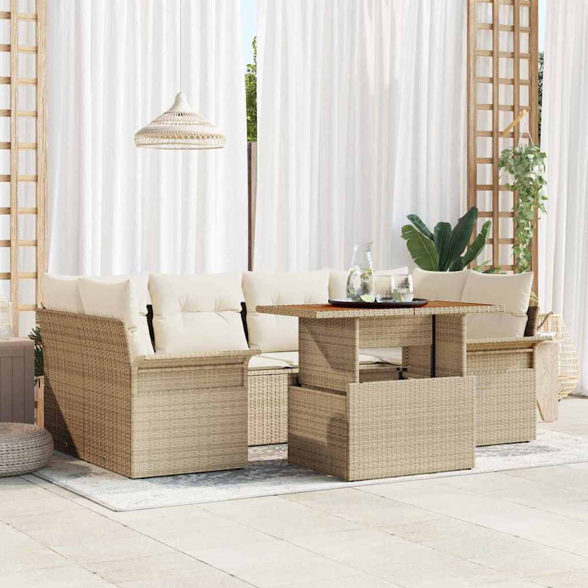 Outdoor-Korbmöbel-Set mit beigefarbenen Kissen und einem Tisch. Weiße Vorhänge und eine Hängelampe im Hintergrund.