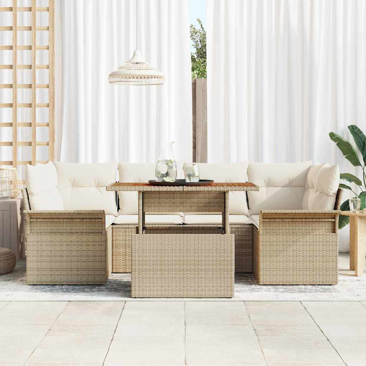 Gartenmöbel-Set aus Rattan mit Kissen. Tisch mit Tablett und Gläsern. Weiße Vorhänge und eine Hängelampe. Pflanzen im Hintergrund.
