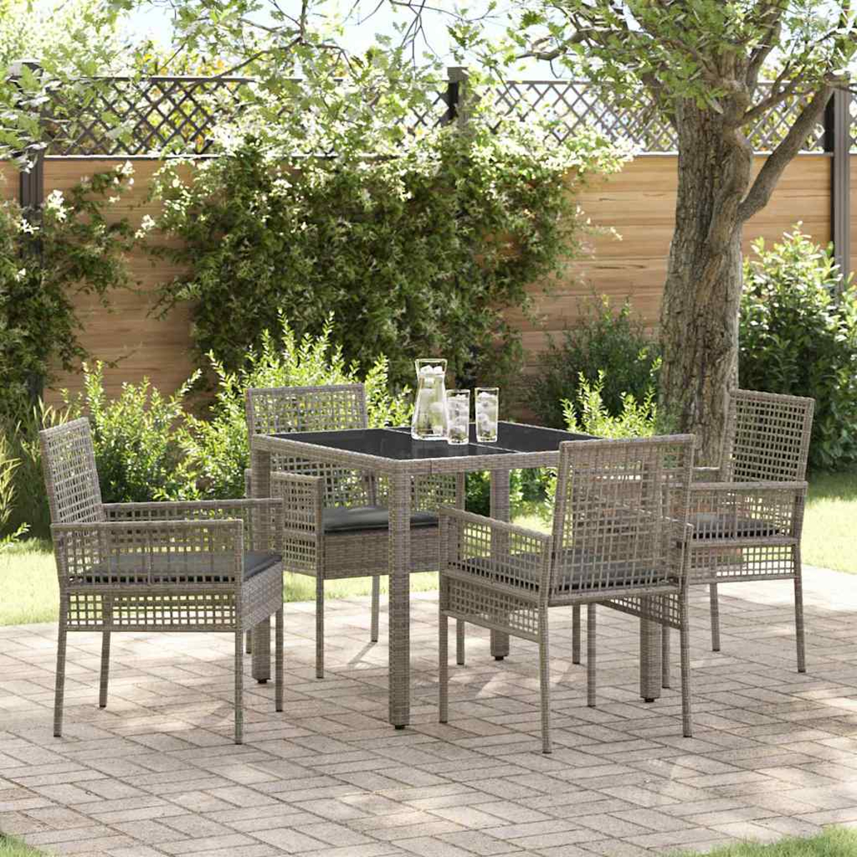 Essgruppe im Freien auf einer Terrasse. Das Set umfasst einen Tisch, vier Stühle und Gläser auf dem Tisch. Hintergrund: Bäume und Zaun.