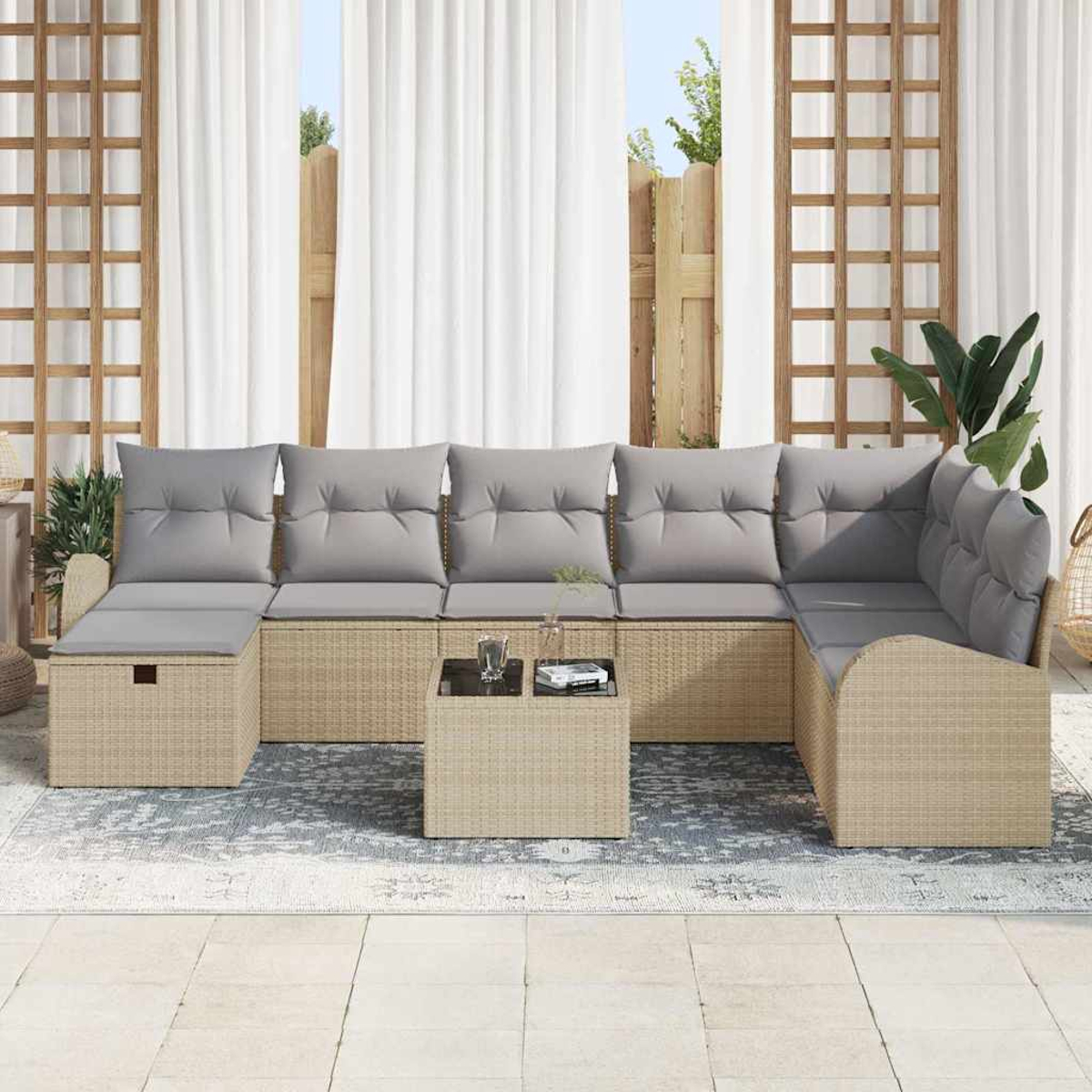 Outdoor-Ecksofa mit grauen Kissen, kleinem Tisch und einem Teppich. Weiße Vorhänge und hölzernen Spalier im Hintergrund.