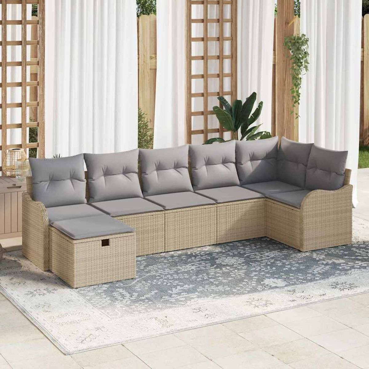 Ein Ecksofa im Freien mit grauen Kissen steht auf einem gemusterten Teppich. Weiße Vorhänge und ein Holzgitter sind im Hintergrund.