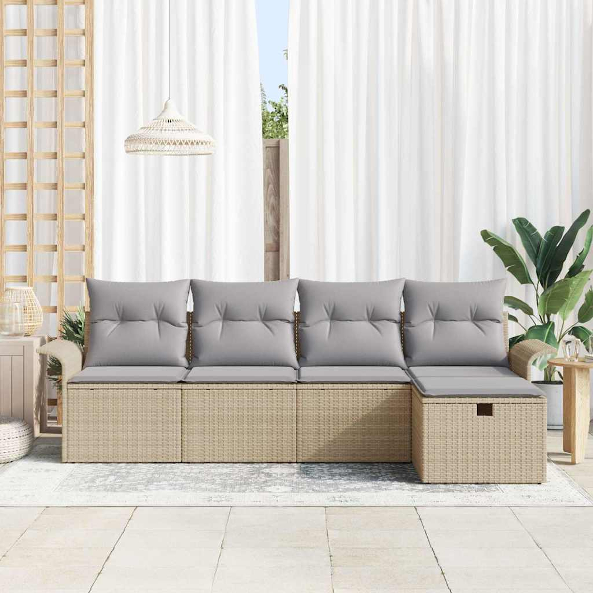 Rattansofa im Freien mit grauen Kissen. Dahinter weiße Vorhänge und eine Hängelampe. Rechts eine Pflanze.