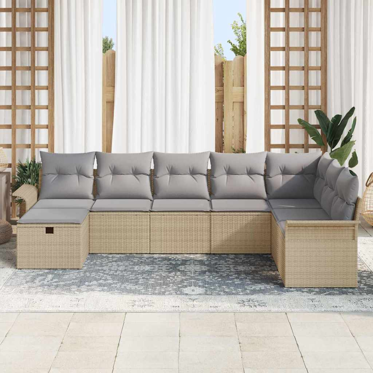 Ein Ecksofa mit grauen Kissen steht auf einem Teppich. Weiße Vorhänge, Holzgitter und Grünzeug rahmen die Szene ein.