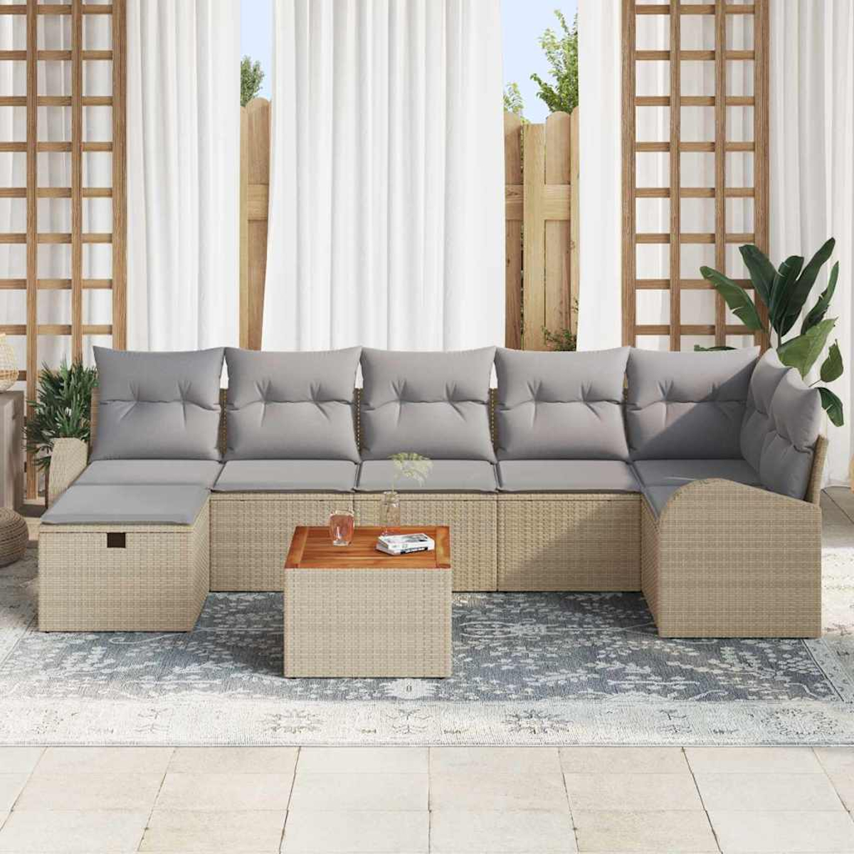Outdoor-Ecksofa mit grauen Kissen. Holztisch, Teppich und weiße Vorhänge sind sichtbar. Pflanzen im Hintergrund.