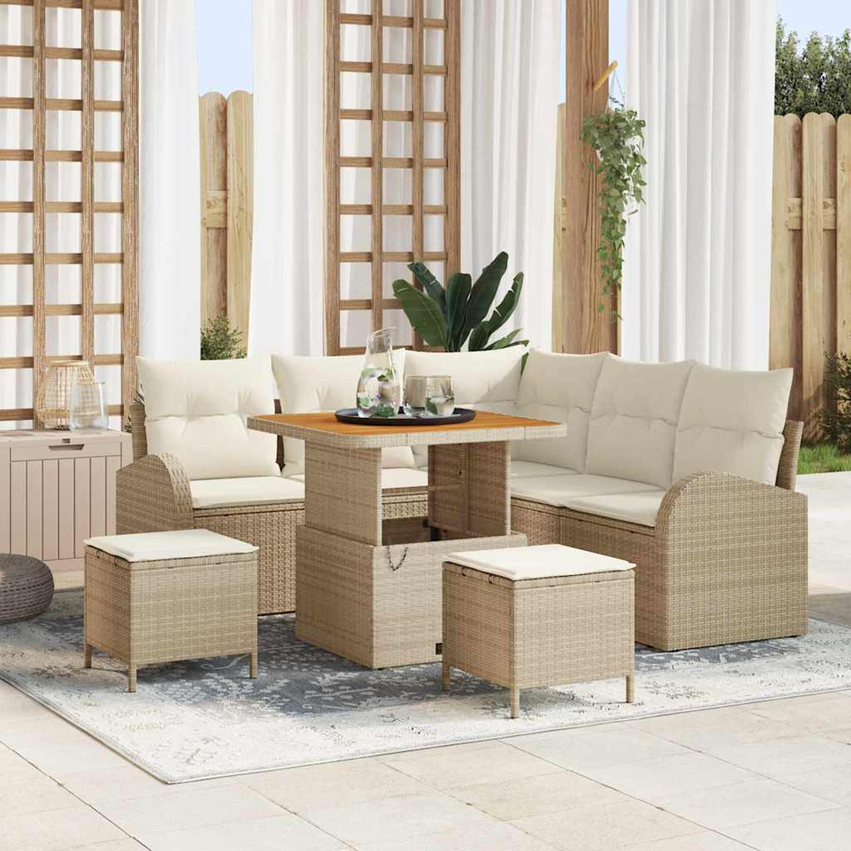 Gartenmöbel-Set aus Korb. Beige Kissen, quadratischer Tisch, zwei Ottomanen und ein Ecksofa auf einem gemusterten Teppich, Vorhänge im Hintergrund.
