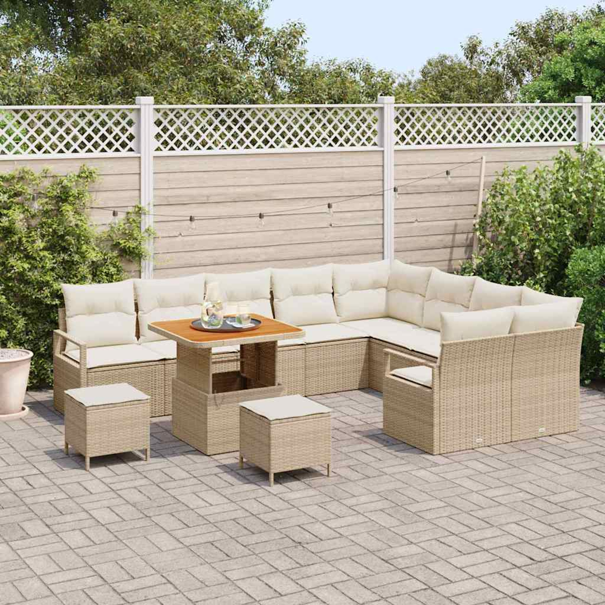 Outdoor-Ecksofa mit beigen Kissen, einem Holztisch mit Getränken und zwei Hockern. Die Terrasse besteht aus grauen Pflastersteinen.