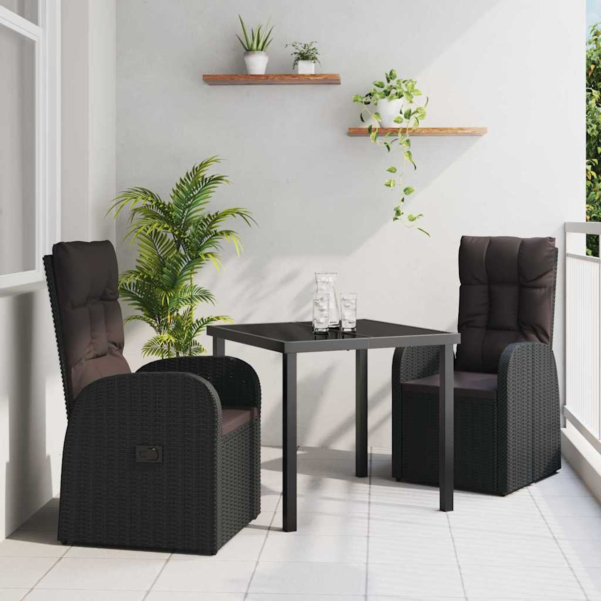 Balkonszene mit schwarzen Korbstühlen, einem Tisch und Pflanzen. Zwei Stühle stehen dem Tisch gegenüber. Pflanzen auf Regalen und in Töpfen.