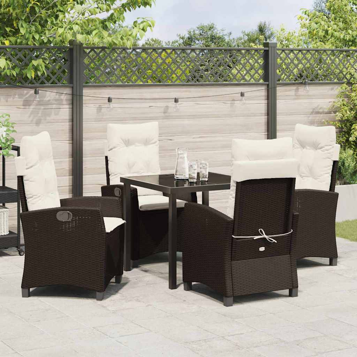 Set da patio all'aperto con tavolo e sedie marrone scuro con cuscini color crema, su un patio piastrellato, recinzione sullo sfondo.