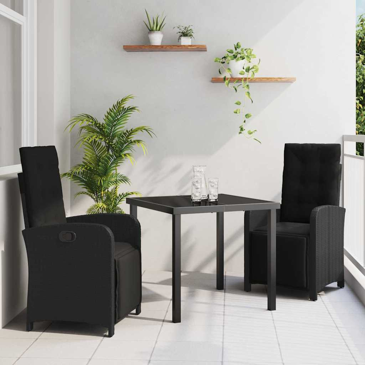 Balkonszene: Schwarze Stühle, Tisch mit Gläsern. Pflanzen auf Regalen und in Töpfen. Weiße Wände und Fliesenboden. Helles Tageslicht.