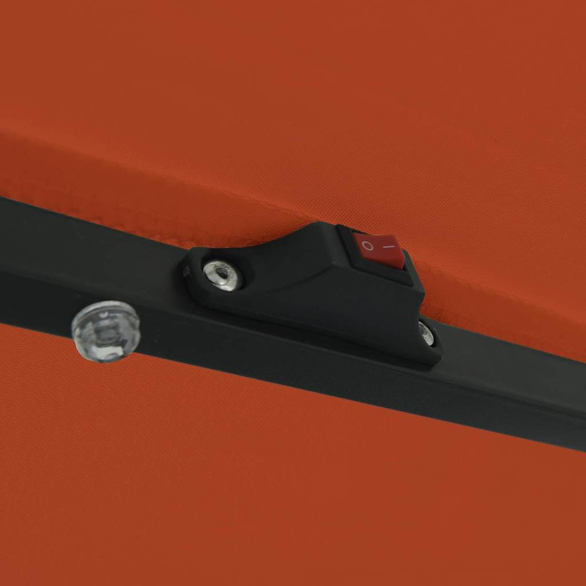 Primo piano di una tettoia arancione con cornice nera. È visibile un interruttore nero con un pulsante rosso. È presente anche una luce trasparente.