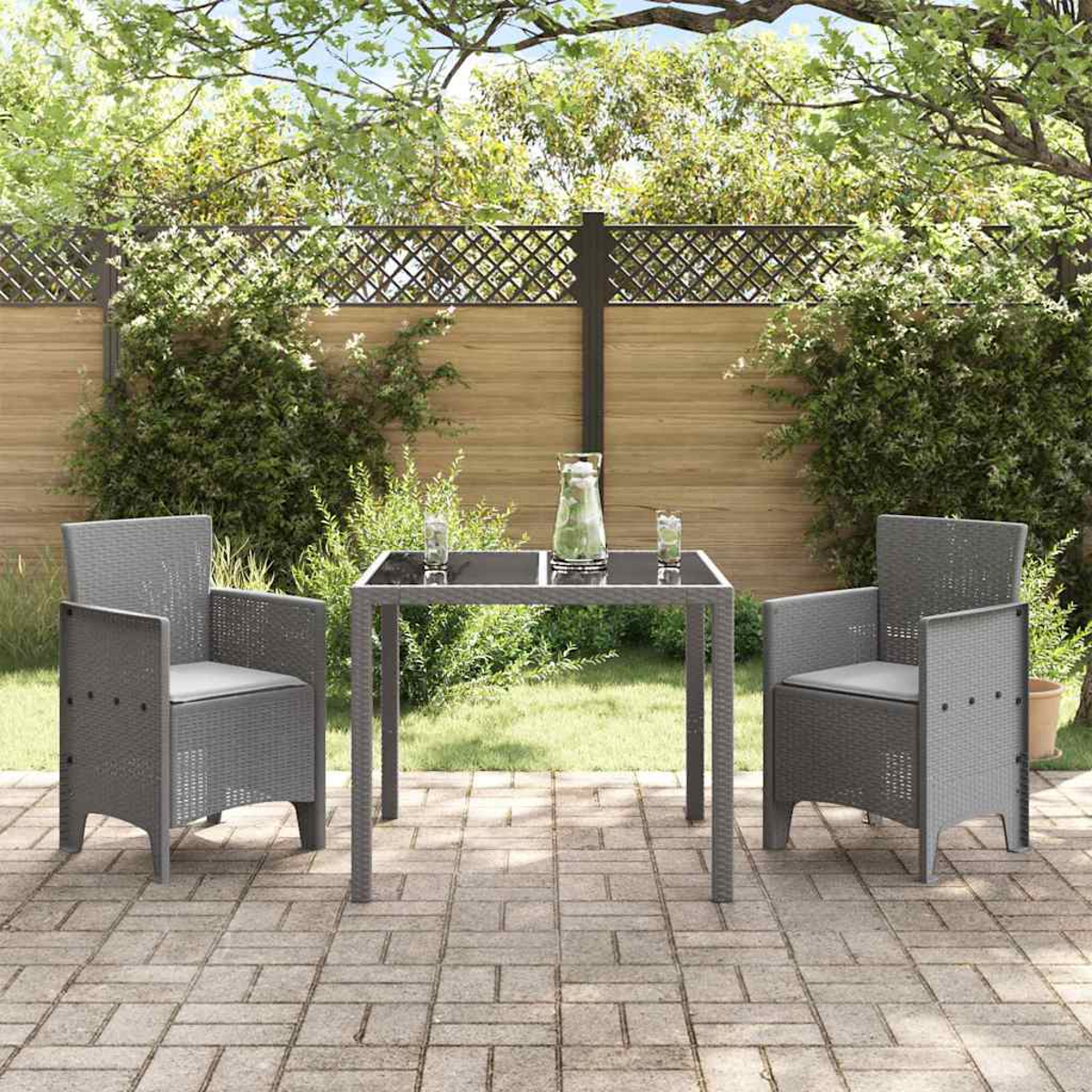 Terrassenset im Freien mit zwei grauen Stühlen und einem Tisch. Im Hintergrund ein Holzzaun, Grün und eine Ziegelterrasse.
