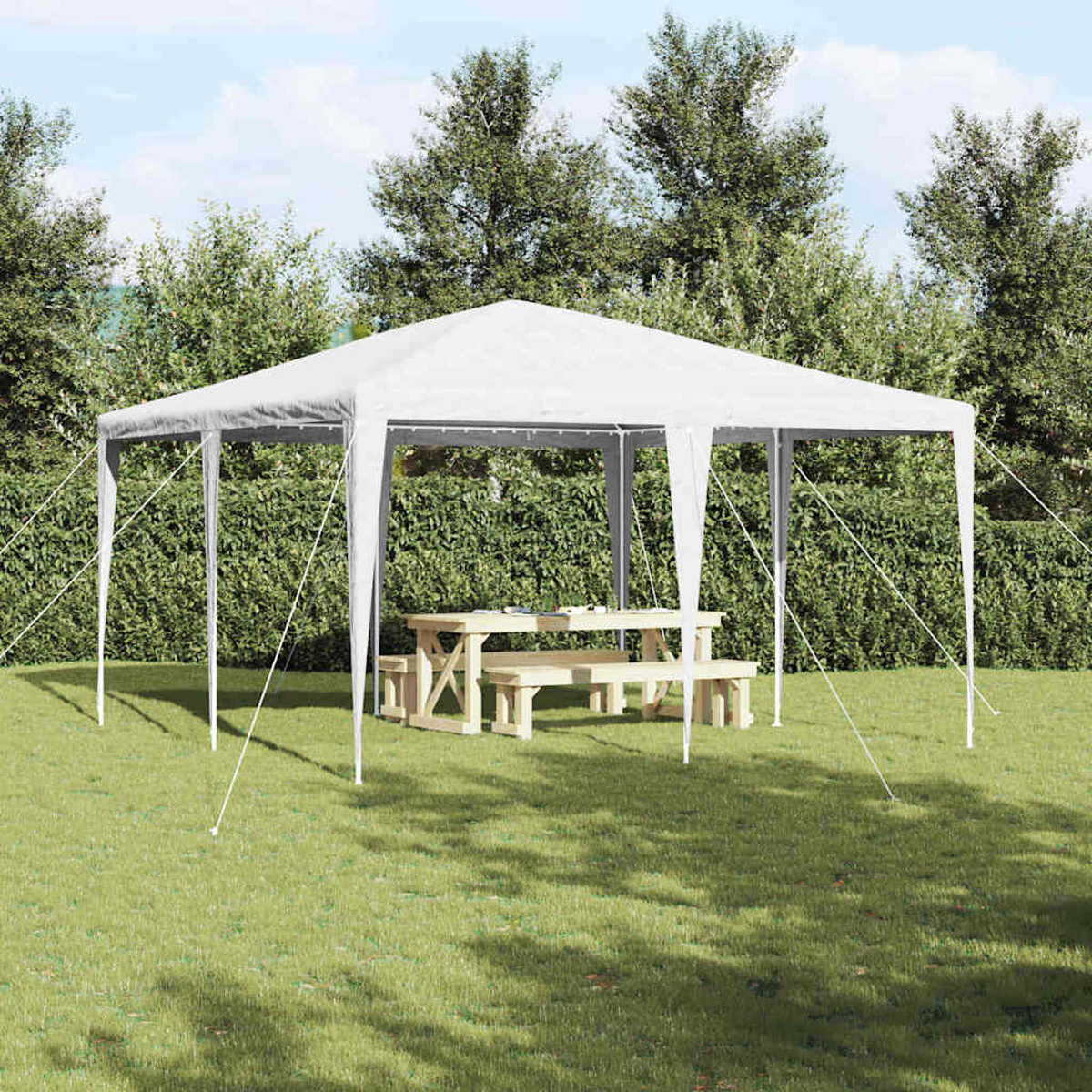 Un gazebo bianco in un'area erbosa con un tavolo da picnic e panche in legno. Cespugli e alberi verdi sullo sfondo.