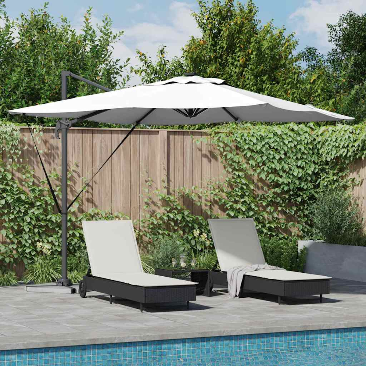 Zwei Liegestühle unter einem weißen Sonnenschirm am Pool. Ein Holzzaun und Kletterpflanzen dahinter, mit Bäumen im Hintergrund.