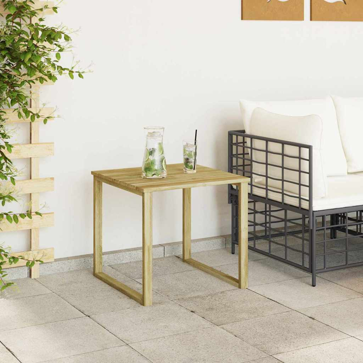 Quadratischer Holztisch mit Glas Wasser und Getränk, neben einem Metallsofa mit weißen Kissen. Links ist eine Pflanze.
