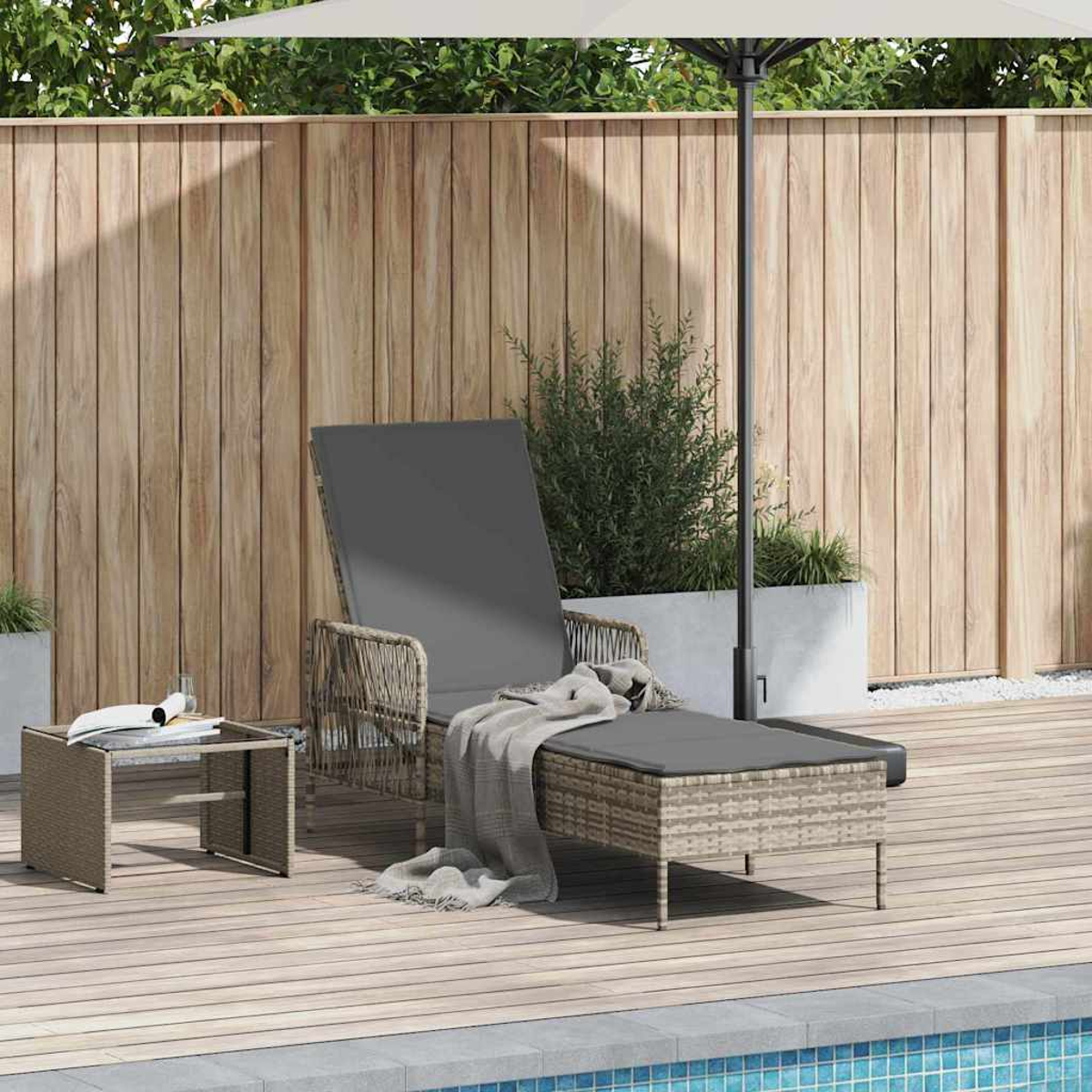 Eine Terrasse mit Liegestuhl, Beistelltisch und Sonnenschirm. Holzzaun im Hintergrund, Pool im Vordergrund.