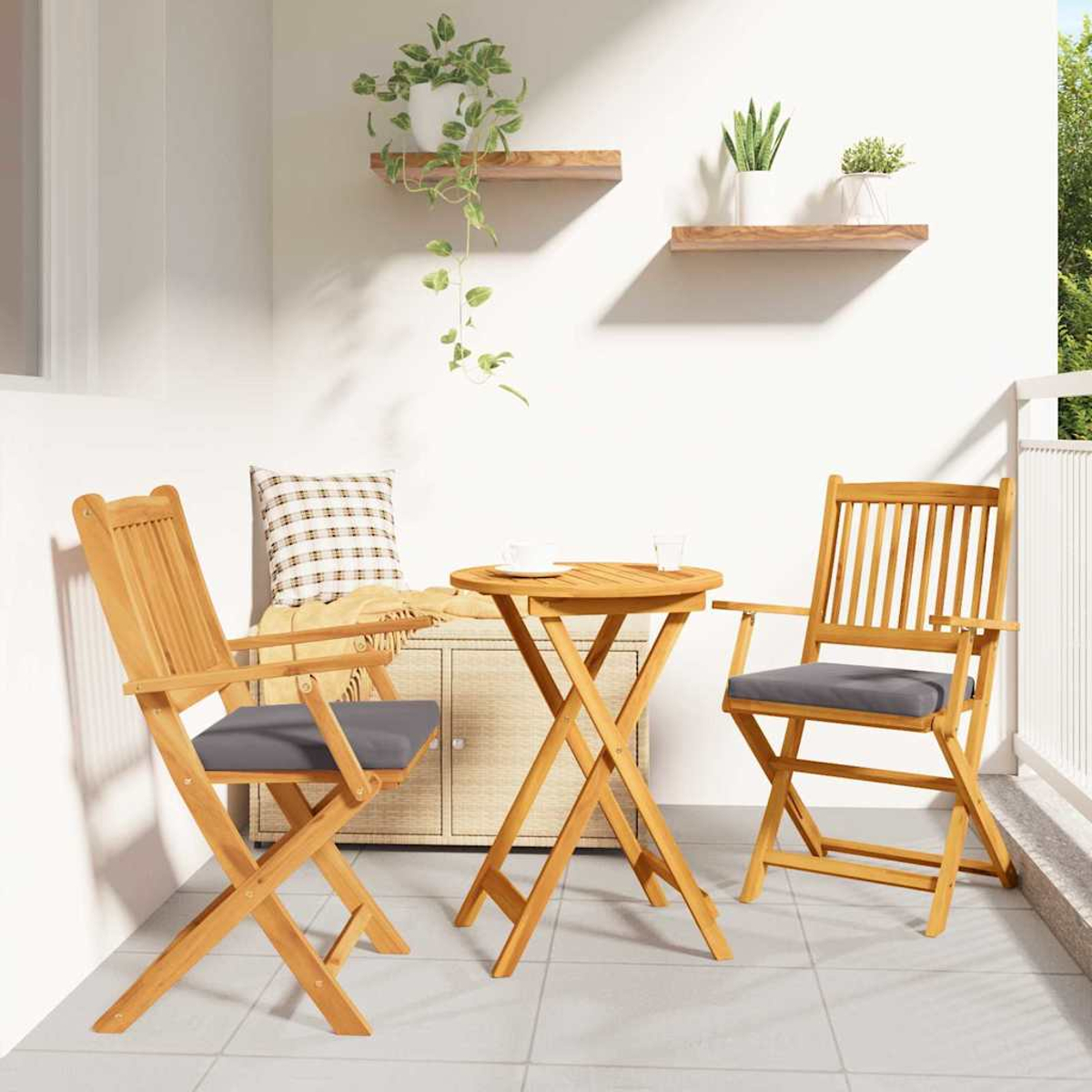 Ein kleines Terrassenset im Freien umfasst zwei Holzstühle und einen Tisch. Zwei Regale mit Pflanzen hängen an der weißen Wand.