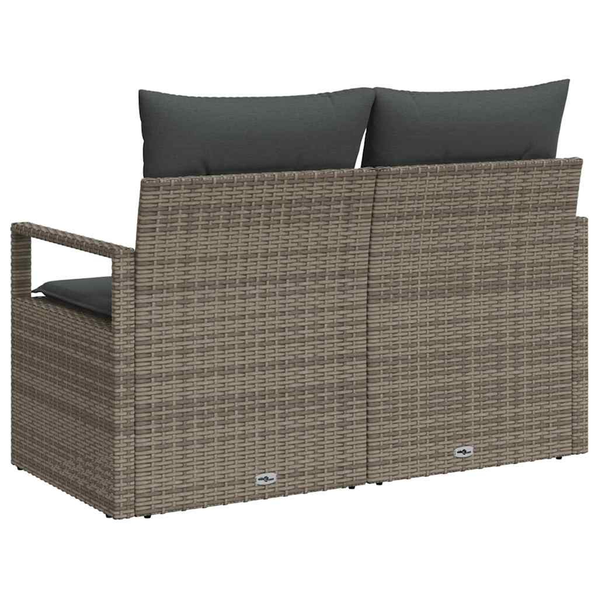 Geflochtene Outdoor-Sofa mit zwei grauen Kissen. Das Sofa ist hellbraun. Die Kissen sind rechteckig und auf der Rückenlehne platziert.
