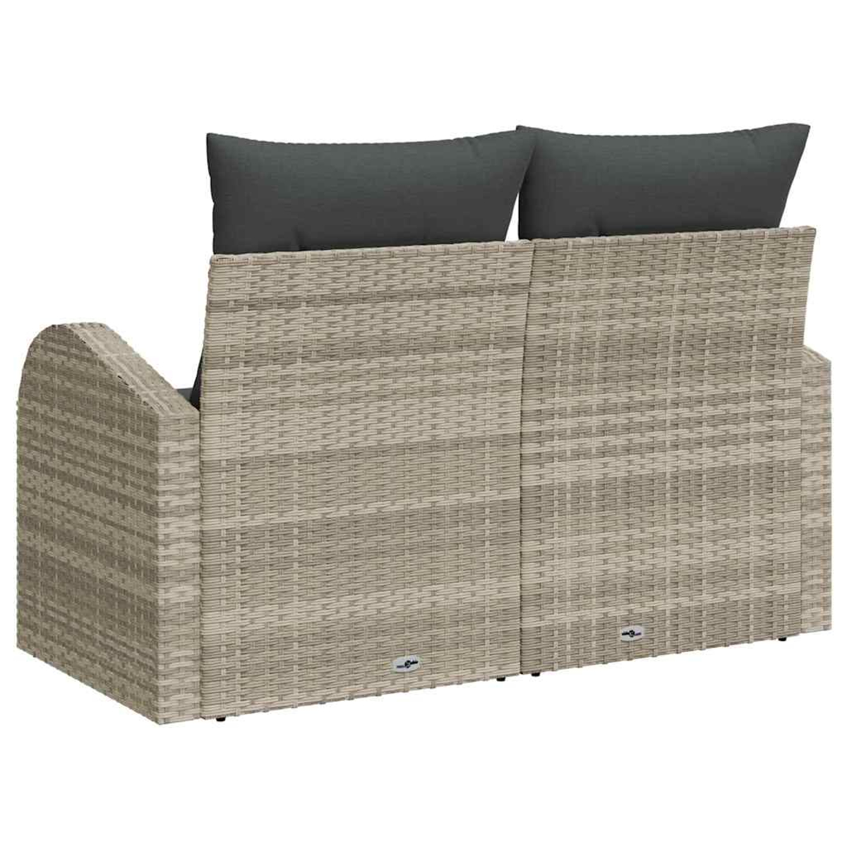 Ein Korbasofa mit zwei grauen Kissen. Das Sofa ist hellbraun mit einem Korbmuster. Es wird von hinten betrachtet.