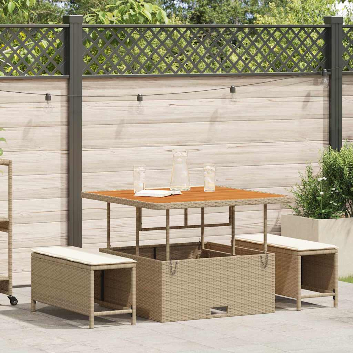 Garten-Set mit Holztisch, Weidenkorb und Bänken. Gläser, eine Kanne und ein Buch liegen auf dem Tisch.