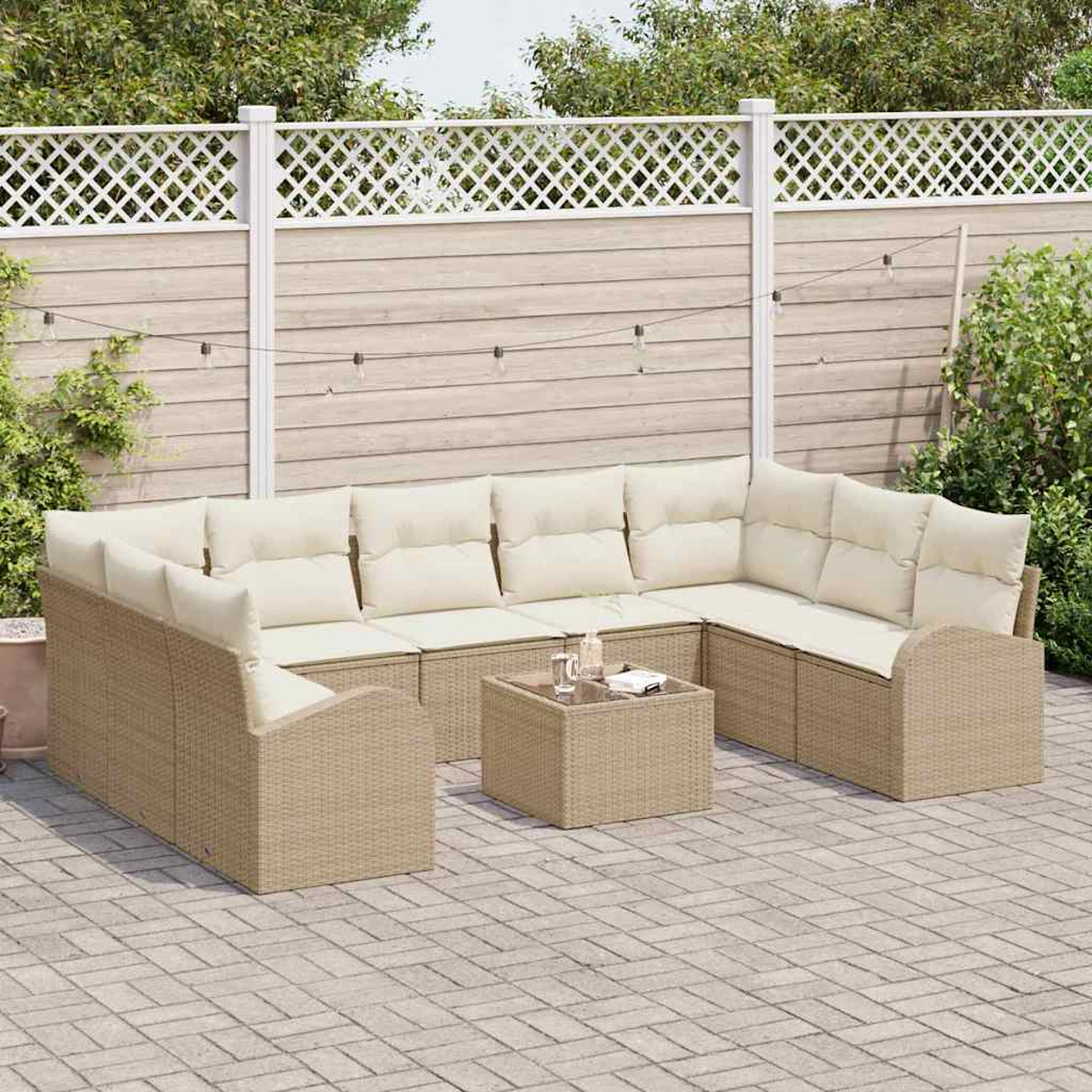 Outdoor-Ecksofa mit cremefarbenen Kissen und einem kleinen Tisch. Auf einer Terrasse mit Zaun im Hintergrund. Lichterketten oben.