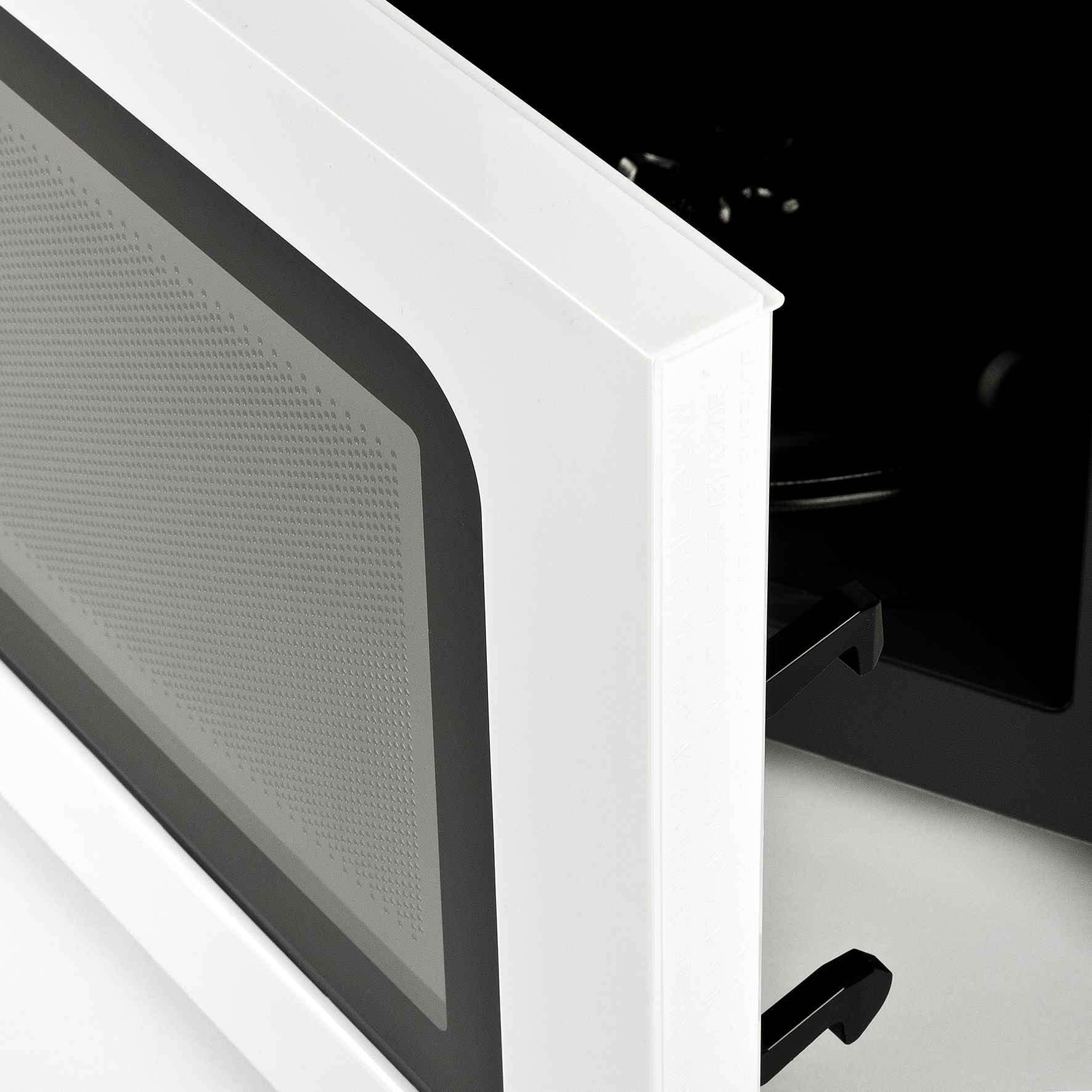 Close-up of a white microwave door partially open. The inside is black, with a handle on the door. The door has a gray interior.