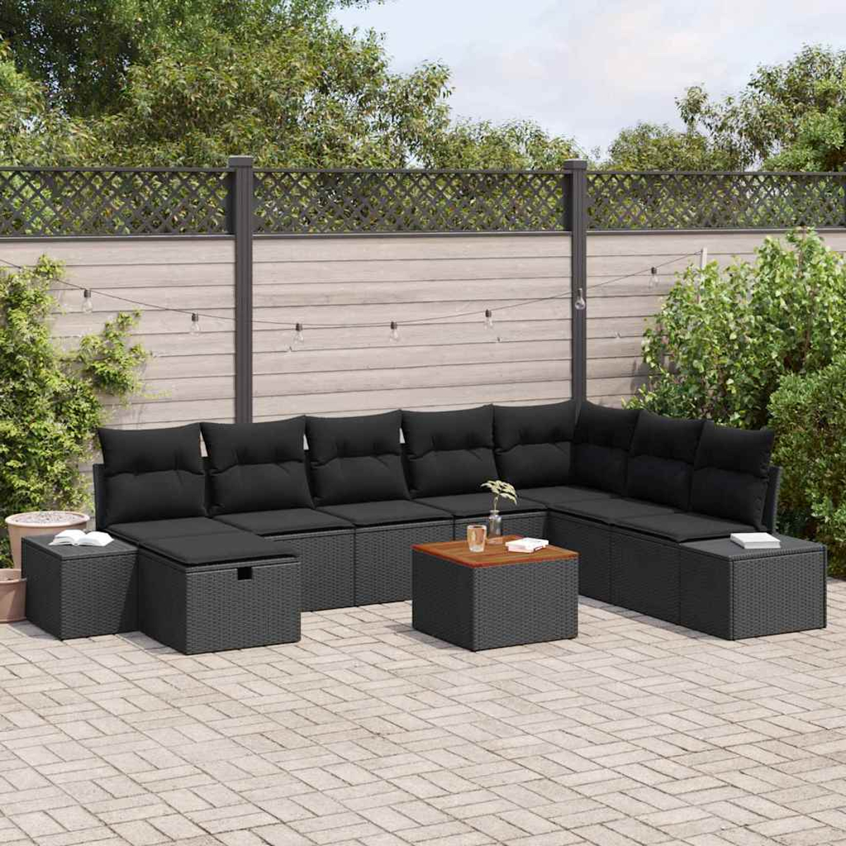 Gartensofa mit schwarzen Kissen, Couchtisch und Stauraum-Ottomanen auf einer Backsteinterrasse, mit Zaun im Hintergrund.