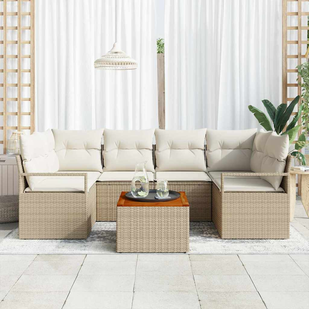 Ein beiges Outdoor-Ecksofa mit cremefarbenen Kissen steht auf einem Teppich. Ein Holztisch trägt ein Tablett mit einer Kanne und Gläsern.