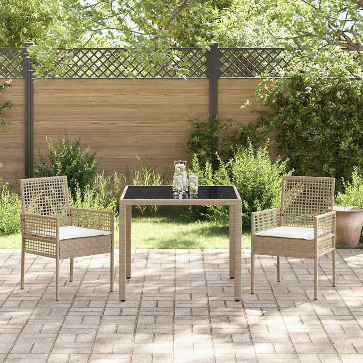 Szene im Freien mit Tisch, Stühlen und Getränken. Im Hintergrund ein Holzzaun mit Pflanzen und Bäumen. Gepflasterte Terrasse.