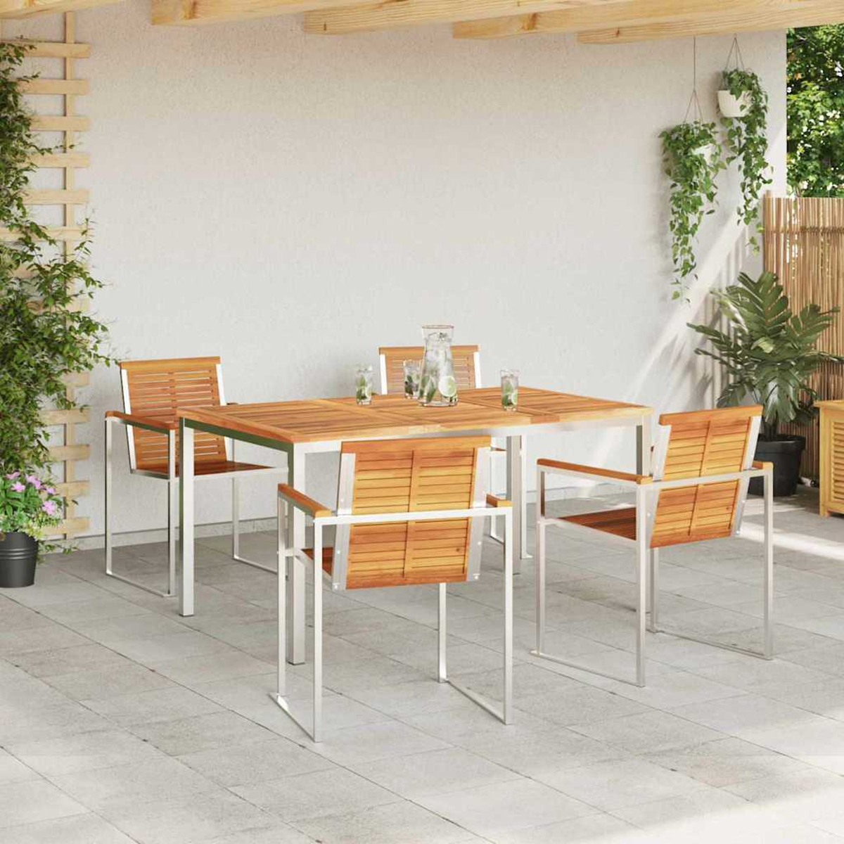 Essgruppe im Freien mit Holztisch und Stühlen. Getränke auf dem Tisch. Pflanzen und Ranken ringsum. Terrasse mit weißer Wand.